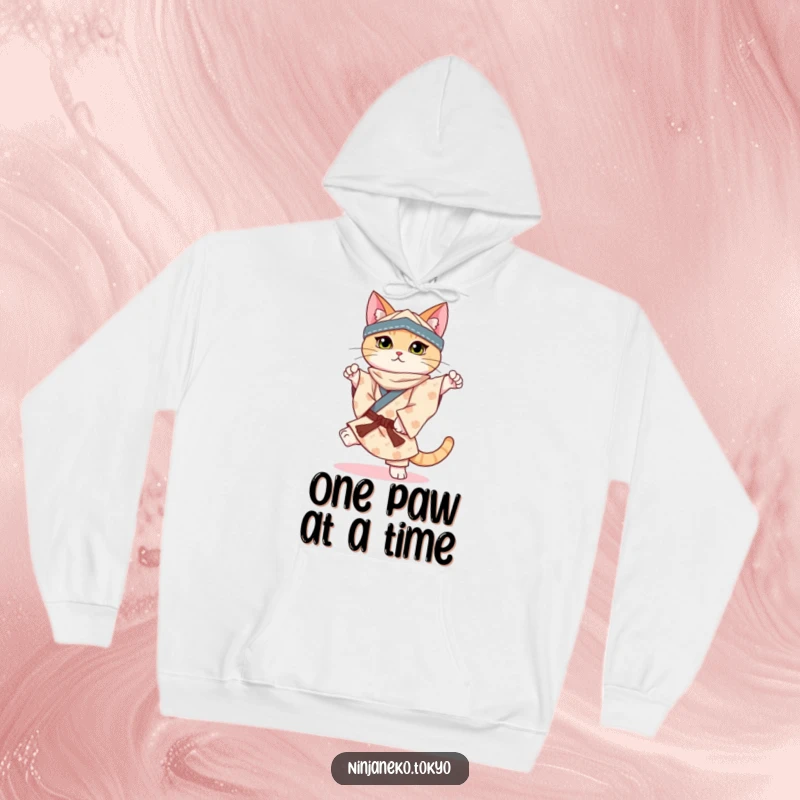 Funny hoodie illustrating a ninja cat in a patterned kimono perfectly balancing on one paw, offering comfort and charm.